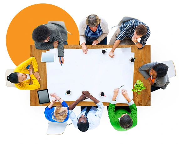 Ocho personas reunidas en una mesa trabajando